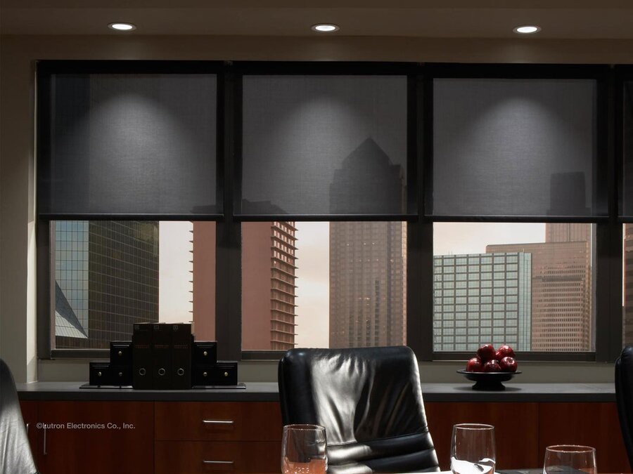 Lutron motorized shades drawn halfway down in a meeting room.